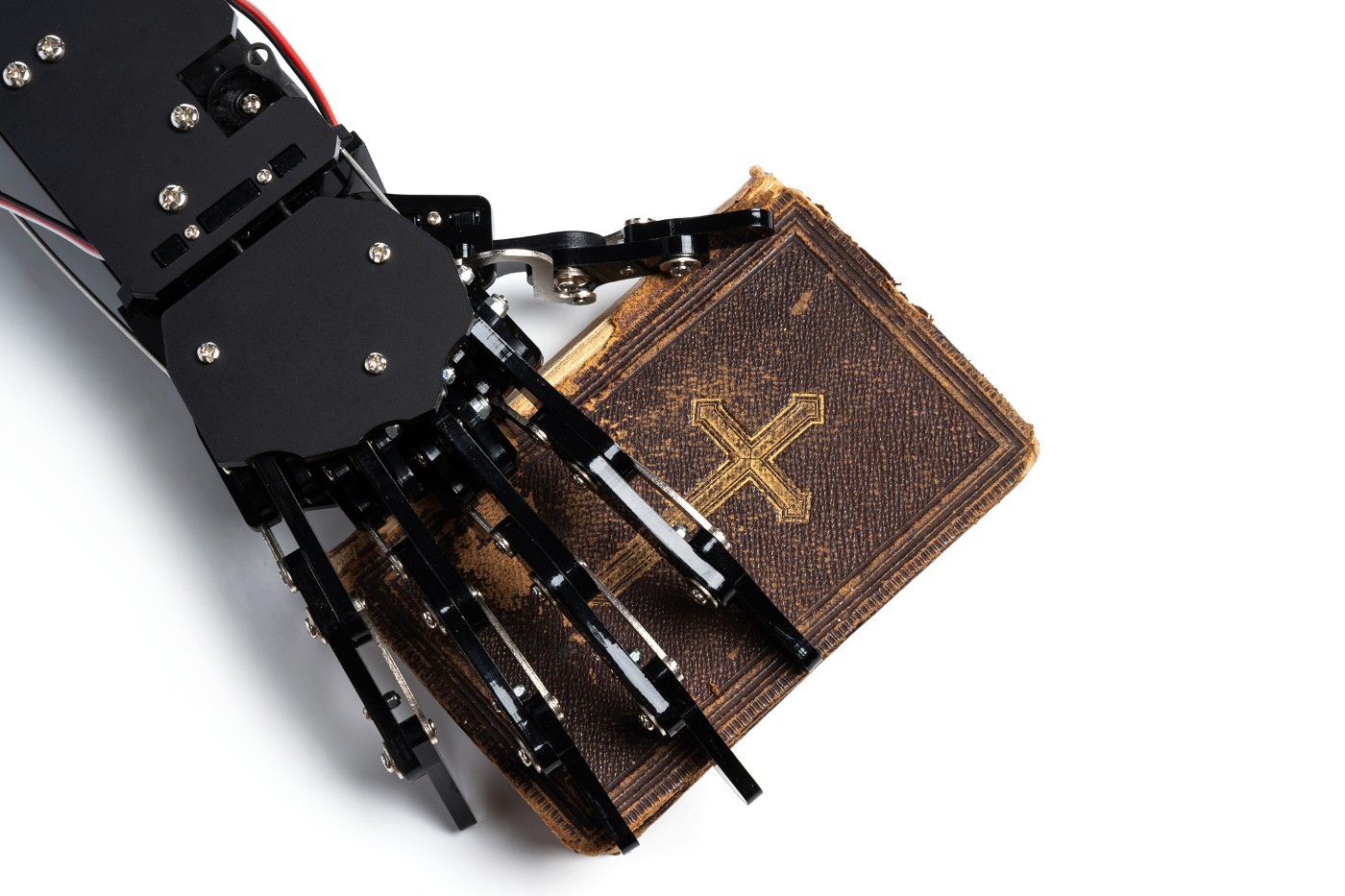 Real robot's hand with ancient Bible