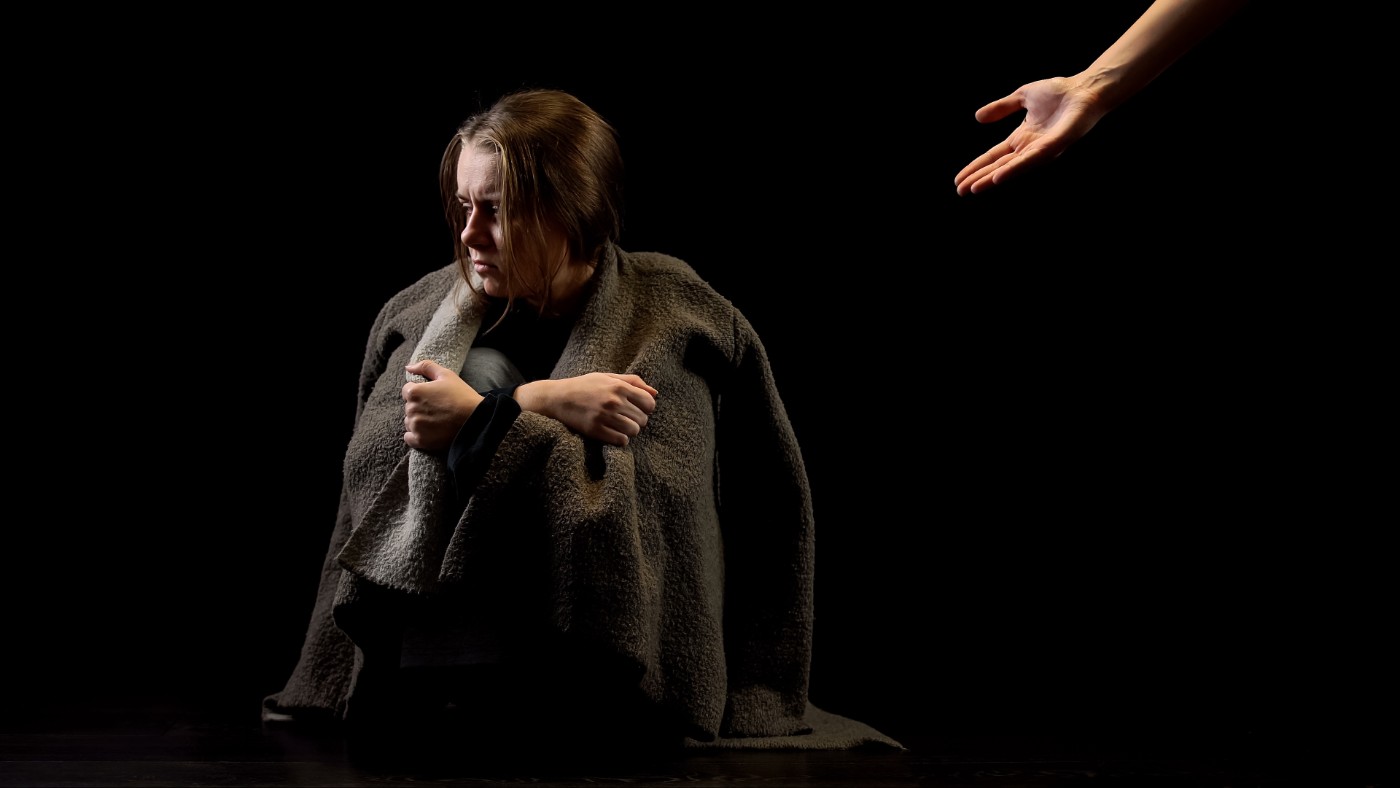 Hand offering help to miserable woman.